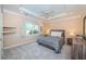 Cozy bedroom with a tray ceiling, neutral color scheme, carpet, and a window with shutters at 1303 Forestedge Blvd, Oldsmar, FL 34677