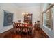 Inviting dining room features hardwood floors, elegant chandelier, and large window with draperies for natural light at 1303 Forestedge Blvd, Oldsmar, FL 34677