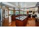 Open-concept kitchen with granite countertops, wood floors, island cooktop, breakfast bar, and natural light at 1303 Forestedge Blvd, Oldsmar, FL 34677