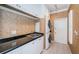 Laundry room with sleek black countertops, white cabinets, and stacked washer and dryer at 1303 Forestedge Blvd, Oldsmar, FL 34677