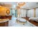 Luxurious bathroom featuring a soaking tub, marble floors, custom cabinetry, and a separate glass-enclosed shower at 1303 Forestedge Blvd, Oldsmar, FL 34677