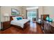 Beautiful main bedroom with hardwood floors, large bed, and a view of the pool area through sliding glass doors at 1303 Forestedge Blvd, Oldsmar, FL 34677