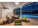 Screened-in lanai with covered seating area with fireplace, outdoor kitchen, and a sparkling pool for relaxation at 1303 Forestedge Blvd, Oldsmar, FL 34677