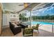 Screened patio area featuring a swimming pool, comfortable seating, and outdoor cooking space at 1303 Forestedge Blvd, Oldsmar, FL 34677