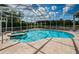 Enjoy this screened-in pool and spa surrounded by tile, with beautiful green scenery in the background at 1303 Forestedge Blvd, Oldsmar, FL 34677