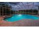 Relax in the screened-in pool and spa with beautiful views, enhanced by outdoor lighting and lush landscaping at 1303 Forestedge Blvd, Oldsmar, FL 34677
