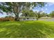 Expansive backyard featuring lush green grass and mature trees, providing ample space for outdoor activities at 1309 11Th W Ave, Palmetto, FL 34221