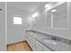Bright bathroom features a double vanity with granite countertop, mirrors, and neutral paint at 1309 11Th W Ave, Palmetto, FL 34221