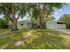 A well-maintained single-story home featuring a charming walkway, lush lawn, and mature trees at 1309 11Th W Ave, Palmetto, FL 34221