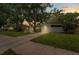 Charming single-story home at dusk with a well-maintained lawn and mature trees providing shade at 1309 11Th W Ave, Palmetto, FL 34221