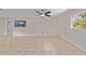 Bright, open living room with tile floors, a ceiling fan, and a large window for natural light at 1309 11Th W Ave, Palmetto, FL 34221