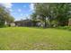Spacious backyard with green grass, enclosed pool area, and partial fencing for privacy at 13503 Gopher Pond Ct, Hudson, FL 34669