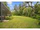Expansive backyard with lush green grass and partial views of screened-in pool area at 13503 Gopher Pond Ct, Hudson, FL 34669