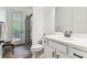 Bathroom with white vanity and tiled floors, plus a glass-enclosed shower leading to an outdoor space at 13503 Gopher Pond Ct, Hudson, FL 34669