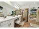 Well-lit bathroom with double sinks, a soaking tub, a walk-in shower, and decorative tile at 13503 Gopher Pond Ct, Hudson, FL 34669