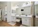 Bright bathroom featuring dual sinks, a vanity area, and a spacious shower with neutral tile at 13503 Gopher Pond Ct, Hudson, FL 34669