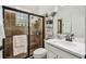Bathroom featuring a glass enclosed tiled shower, white vanity, and modern fixtures with decorative wall shelving at 13503 Gopher Pond Ct, Hudson, FL 34669