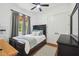 Bright bedroom boasts a black bed frame, wood floors and stylish grey curtains filtering natural light at 13503 Gopher Pond Ct, Hudson, FL 34669