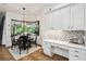 Cozy breakfast nook with white cabinets, built-in desk, tiled backsplash, and natural light at 13503 Gopher Pond Ct, Hudson, FL 34669