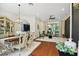 Elegant dining area featuring chandelier, hardwood floors, and seamless access to the patio at 13503 Gopher Pond Ct, Hudson, FL 34669