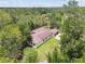 Large home blending into a wooded landscape, showcasing its expansive size at 13503 Gopher Pond Ct, Hudson, FL 34669