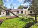 Charming exterior featuring stucco, an arched entryway, and professionally landscaped yard at 13503 Gopher Pond Ct, Hudson, FL 34669