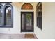 Inviting front door with decorative wreath, arched window, and charming 