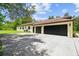 Spacious multi-car garage with modern doors, ample parking, and lush greenery nearby at 13503 Gopher Pond Ct, Hudson, FL 34669