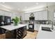 Bright kitchen boasts white cabinets, quartz countertops, stainless appliances, and an island with wine storage at 13503 Gopher Pond Ct, Hudson, FL 34669