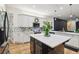 Open kitchen with white cabinets, stainless appliances, a large island, and tile floors at 13503 Gopher Pond Ct, Hudson, FL 34669