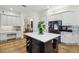 Open kitchen featuring an island with wine storage, white cabinets, and modern appliances at 13503 Gopher Pond Ct, Hudson, FL 34669