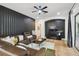 Modern living room features a comfortable leather sectional sofa, decorative black accent wall and stylish ceiling fan at 13503 Gopher Pond Ct, Hudson, FL 34669