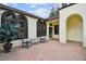 Relaxing outdoor patio with brick flooring, comfortable seating, and charming architectural details at 13503 Gopher Pond Ct, Hudson, FL 34669