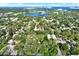An aerial view captures a neighborhood near a serene lake, with houses nestled among mature trees and greenery at 1359 S Michigan Ave, Clearwater, FL 33756