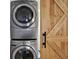 Stacked washer and dryer beside a wooden barn door at 1359 S Michigan Ave, Clearwater, FL 33756