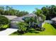 Aerial view of a beautifully landscaped home with a well-maintained lawn and mature trees at 14427 Pepperpine Dr, Tampa, FL 33626
