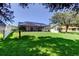 Large backyard with a screen-enclosed patio and mature trees provides a perfect space for outdoor enjoyment at 14427 Pepperpine Dr, Tampa, FL 33626