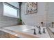Close-up of a modern soaking tub with chrome fixtures and tiled surround, perfect for relaxation at 14427 Pepperpine Dr, Tampa, FL 33626