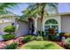 Inviting entrance with tropical landscaping and a well-manicured lawn at 14427 Pepperpine Dr, Tampa, FL 33626