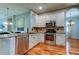 Bright kitchen with stainless steel appliances, granite countertops, and wood flooring at 14427 Pepperpine Dr, Tampa, FL 33626