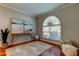 Sunlit living room featuring a decorative rug, arched window, and wood floors at 14427 Pepperpine Dr, Tampa, FL 33626