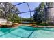 Relaxing screened-in pool and spa offering picturesque views of the adjacent lake at 14427 Pepperpine Dr, Tampa, FL 33626