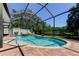 Sparkling screened-in pool and spa area with a view of the tranquil lake at 14427 Pepperpine Dr, Tampa, FL 33626