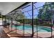 Screened pool area boasts a hot tub and views of a tranquil backyard pond, perfect for relaxation at 14427 Pepperpine Dr, Tampa, FL 33626