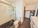 Bathroom showcasing a marble-tiled shower with black-tiled floor, toilet, and shelving unit at 1972 Briarwood St, Dunedin, FL 34698