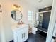 Modern bathroom featuring a tiled walk-in shower, black-and-white tile flooring, and a vanity at 1972 Briarwood St, Dunedin, FL 34698