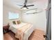 Cozy bedroom with ceiling fan, a surfboard decoration, and wood-look flooring at 1972 Briarwood St, Dunedin, FL 34698