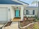 Charming home featuring a vibrant blue front door and well-maintained landscaping at 1972 Briarwood St, Dunedin, FL 34698