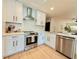 Modern kitchen with white cabinets, stainless steel appliances, and wood-look flooring at 1972 Briarwood St, Dunedin, FL 34698