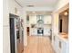 Bright, open kitchen features modern stainless steel appliances, white cabinetry, and wood-look flooring at 1972 Briarwood St, Dunedin, FL 34698